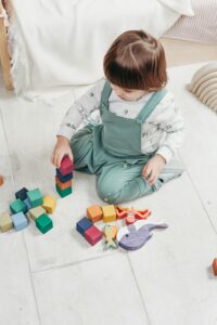 A Child Sitting on The Floor Playing With Toys